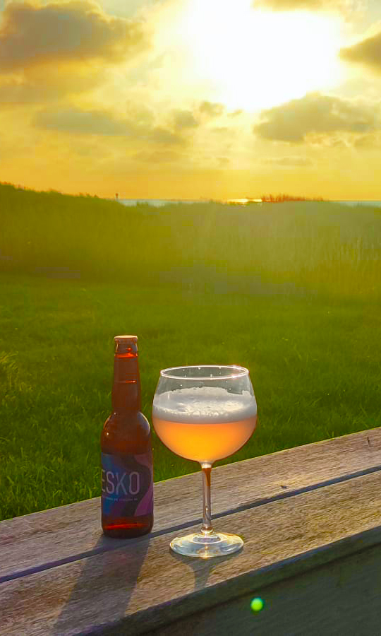 afbeelding van een ondergaande zon met een heerlijk glas ESKo ervoor.